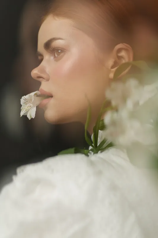 Portrait of a beautiful young model with a flower, showcasing natural beauty and elegance, perfect for wellness and skincare concepts