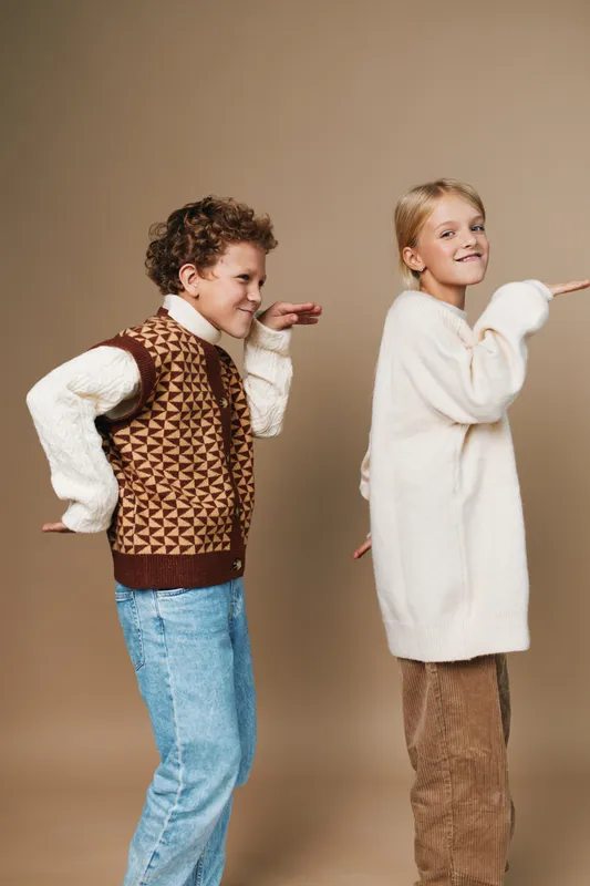 Authentic scene of two children in cozy outfits, capturing a candid moment of a playful game and school inspired lifestyle, with joyful posture and bright energy.