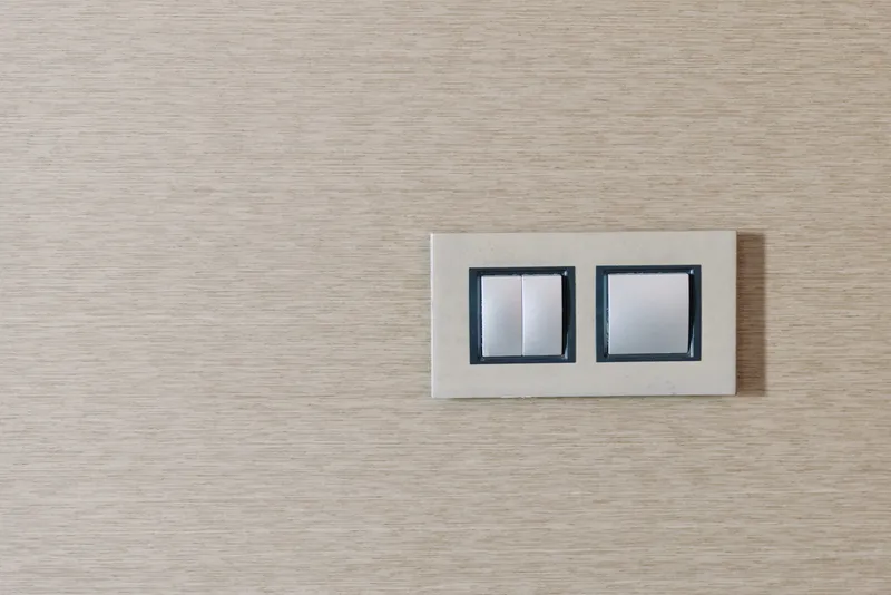 Double switch on a wooden wall, close up of a modern electrical fixture in a minimalist interior design with clean lines and natural textures.