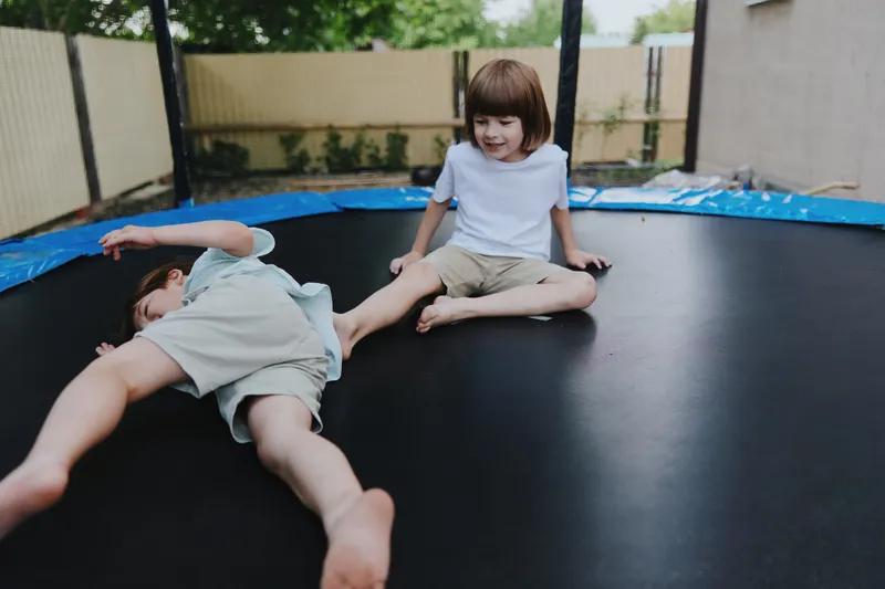 Happy children playing on a trampoline, enjoying carefree moments of friendship and laughter while embracing active outdoor fun. ###
