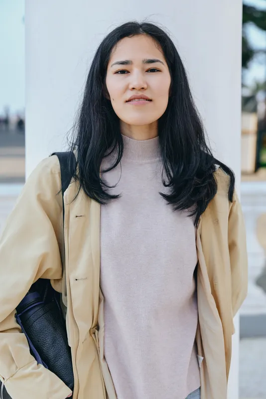Fashion, street style, autumn outerwear, casual elegance in an urban setting, woman wearing a beige trench over a soft knit, confident pose, natural light, city backdrop