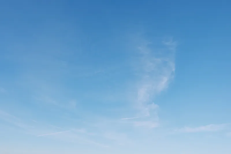 Clear blue sky with wispy clouds across the horizon, a serene expansive backdrop for nature, travel and outdoor scenes, conveying calm, openness and gentle daylight.