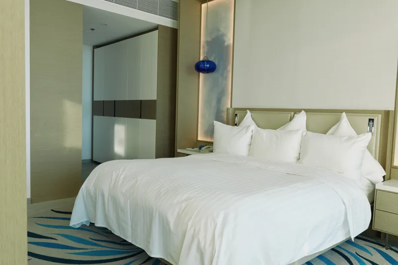 Bed, bedroom, hotel, interior, white, linens, pillows, lighting, decor, calm atmosphere with a large white bed, plush pillows and modern decor for a restful, comfortable stay.