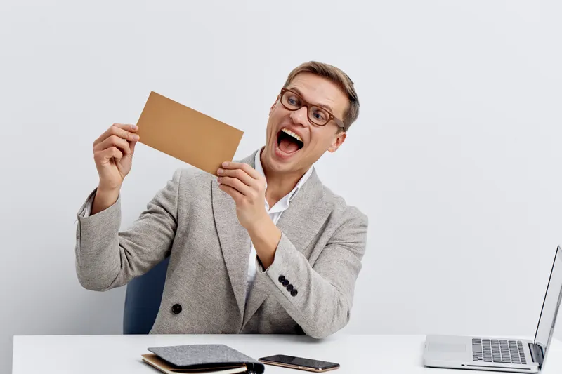 Excited young caucasian man holding envelope sit at desk laptop smart home automation technology concept