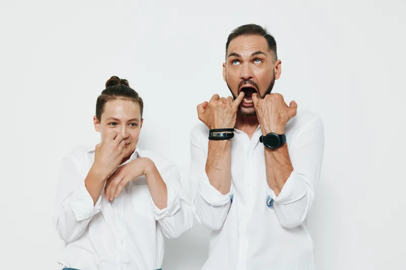 A confident male business professional on an isolated colored background shows bold emotion and surprise, standing with a teammate, conveying energy and focus in a modern workplace scenario.