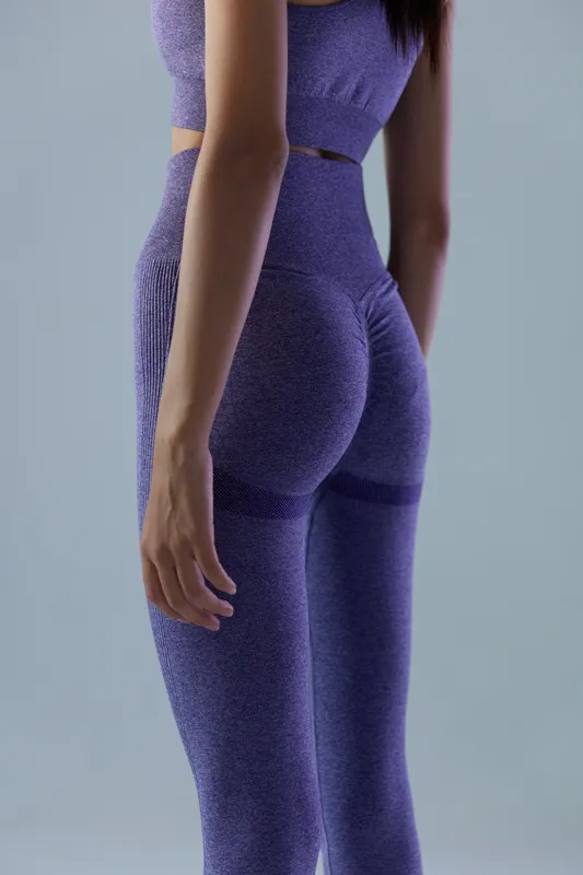 woman sport fitness wearing seamless purple leggings, close-up of athletic figure, smooth texture and toned legs, minimalistic background, healthy lifestyle concept