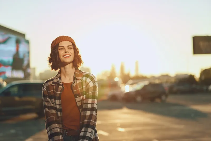 Woman smile candid golden urban beanie plaid lifestyle portrait of a young woman laughing at sunset, showcasing authenticity, candid lifestyle and golden hour glow with mindful living and emotional