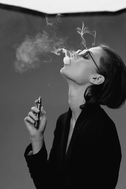 Woman vaping black and white stylish smoke glasses casual