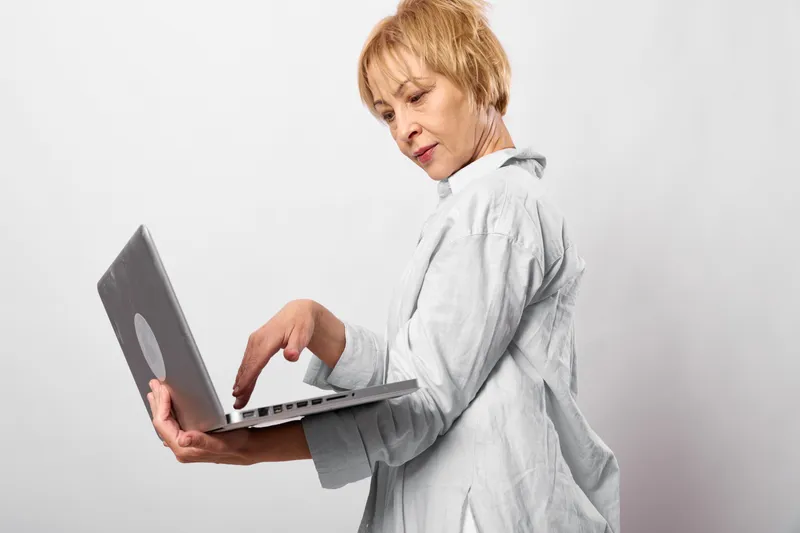 Woman with laptop, isolated on white background, focused profile portrait, remote work and communication concept, modern technology, soft studio light, clean