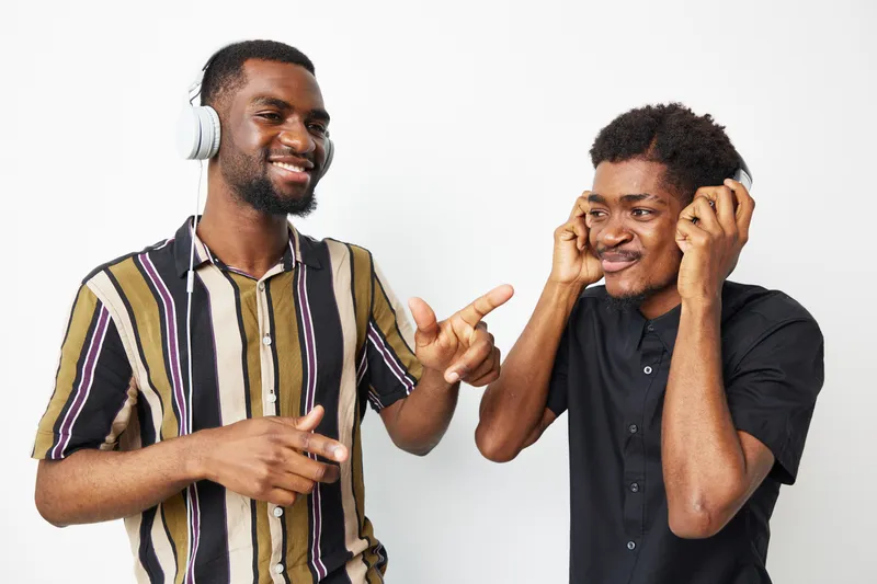Joyful black men enjoying music together, radiating happiness and friendship while wearing headphones. Perfect for lifestyle and music themes.