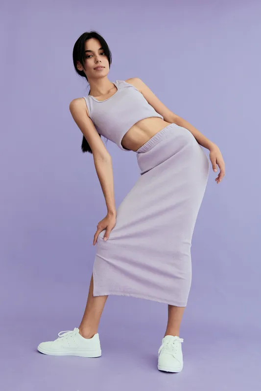 woman posing in lilac knitted outfit with white sneakers on purple background, fashion style, casual wear, young adult, studio lighting
