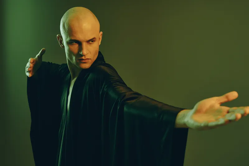 Black and white portrait of a man demonstrating martial arts, showcasing strength and focus with an intense expression, embodying the spirit of discipline.