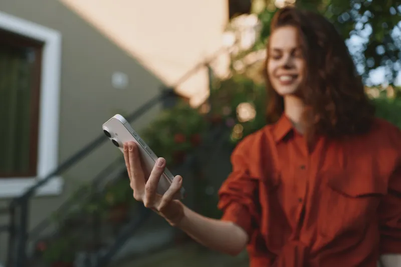 Joyful woman lifestyle selfie outdoor smiling casual portrait daytime happiness sunshine relaxed urban street scene, candid moment of everyday confidence