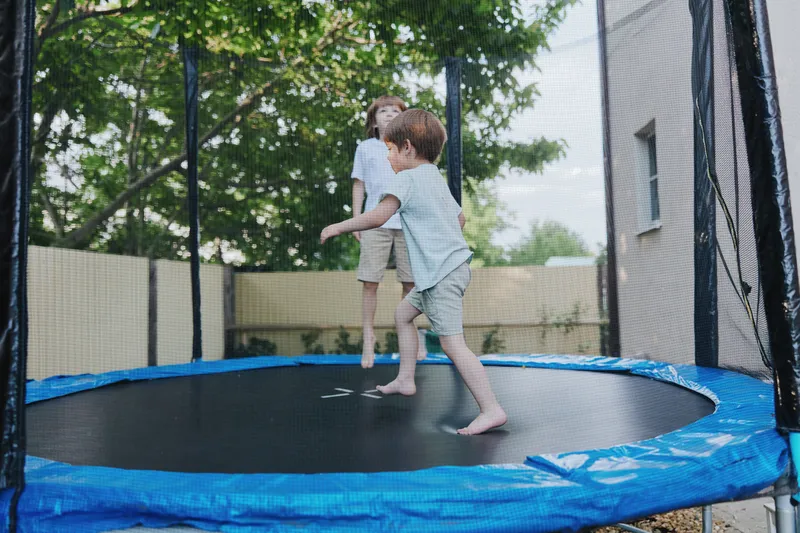 Happy children jumping on a trampoline, enjoying a sunny day outdoors. Their laughter fills the air as they embrace the joy of play and friendship.