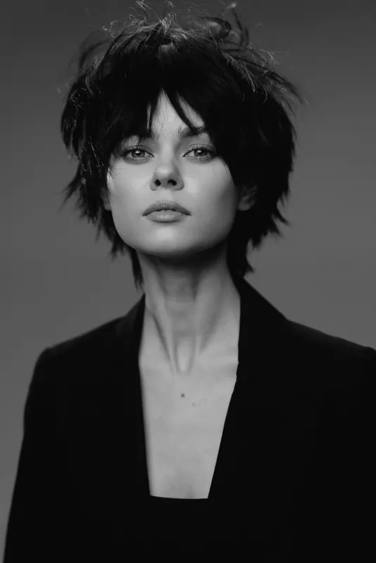 black and white portrait of a stylish woman with short hair wearing a blazer looking confidently