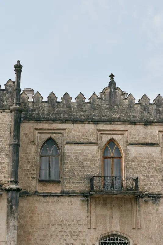 Building facade with gothic stone window and small balcony, historic architecture detail