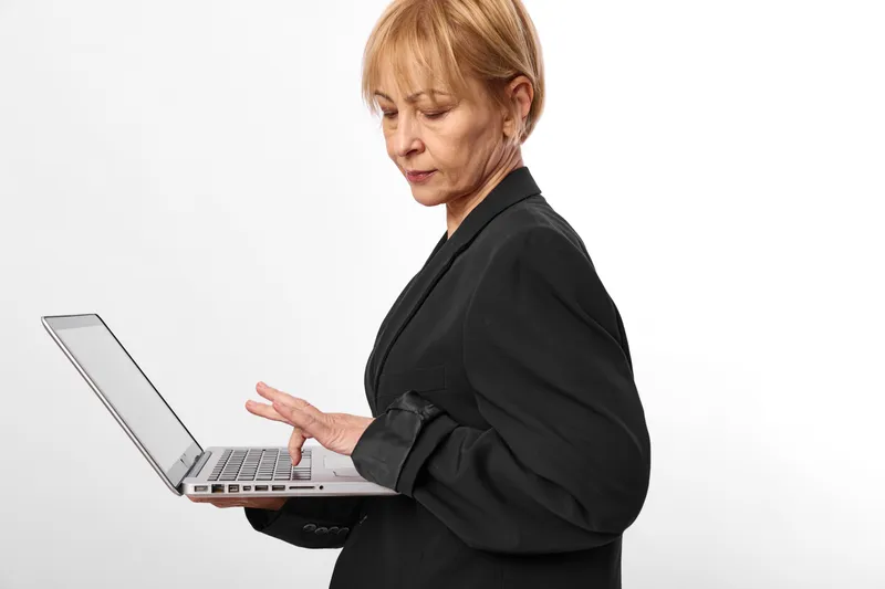 Woman laptop business office typing female technology work communication focus concept, professional woman in black jacket typing on open laptop, white background