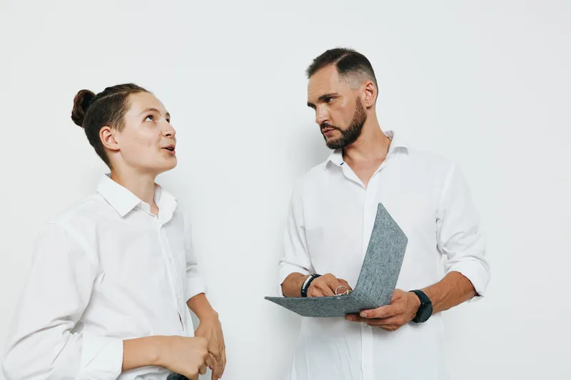 Two professional men, one younger and one older, discuss ideas with a focused expression against an isolated colorful background, conveying teamwork, leadership, and business readiness.