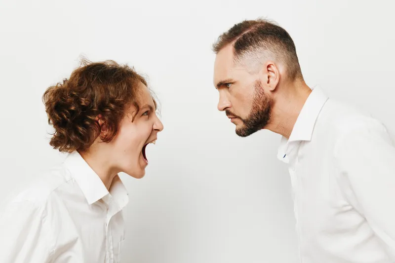 A tense business moment with a professional man facing another, displaying strong emotions against a colored isolated background. The scene emphasizes leadership, determination, and dynamic