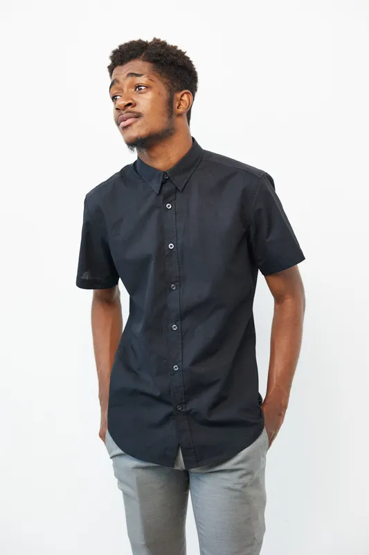 Stylish black man in a fashionable shirt, showcasing a confident expression against a clean white background. Perfect for lifestyle and fashion themes.
