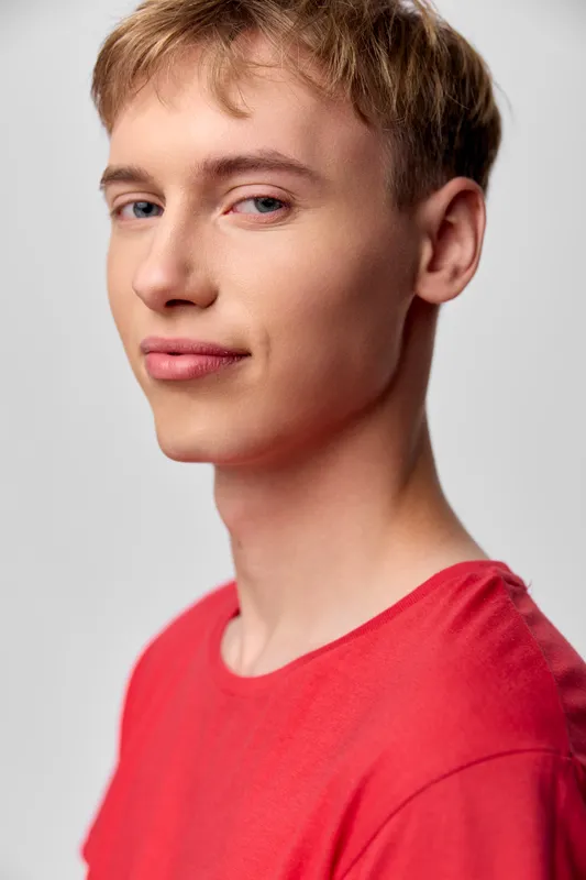 Young man, red shirt, confident, closeup, headshot with studio lighting, relaxed pose and natural expression for lifestyle, fashion, or branding use.