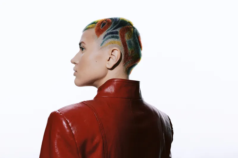 woman with colorful short hair wearing red leather jacket, side profile, creative hairstyle, modern fashion, isolated white background, expressive look