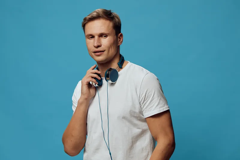 young caucasian man with headphones standing isolated on blue background digital detox concept casual wear lifestyle portrait