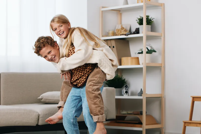Authentic scene of playful interaction between caregiver and child, showcasing a game themed moment at home that blends everyday life with learning, school routines, and family bonding.