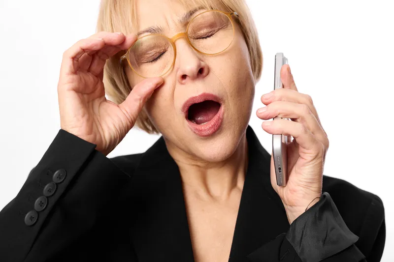 Skincare selfcare with woman applying eye cream, beauty closeup face in studio, white background, professional suit, she relaxes with open mouth, wellness