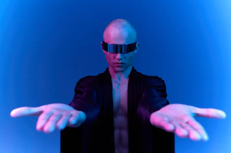 Futuristic man with hands outstretched, showcasing a modern aesthetic. The striking blue light enhances the captivating atmosphere and intriguing look of the image.