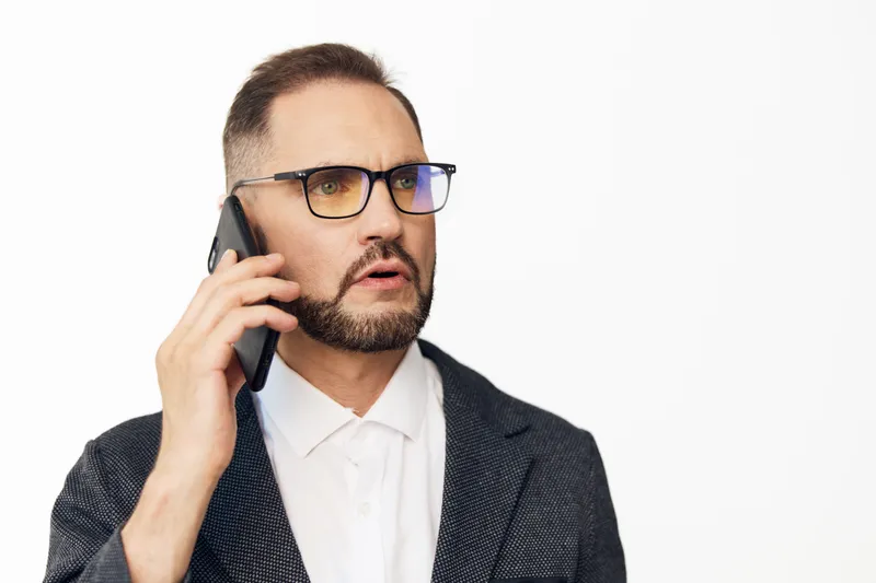 Professional man on a business call with a focused yet confident emotion, isolated white background, clean and polished corporate portrait.