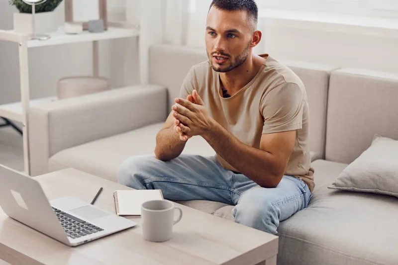 Engaged man discussing ideas during a video call, showcasing modern workspace aesthetics and a relaxed atmosphere that enhances productivity and creativity.