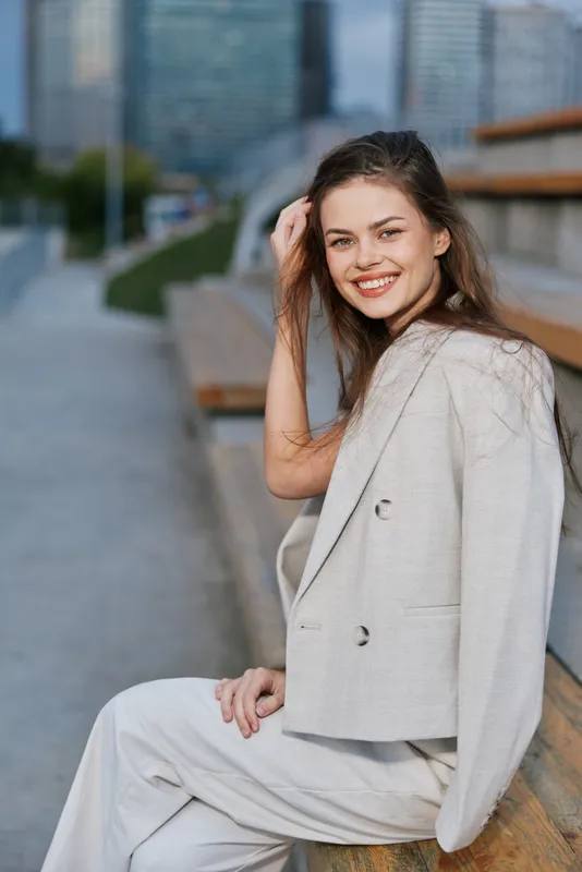 smiling woman in beige business suit outdoors urban background casual confident young adult