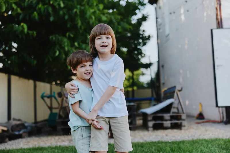Happy children play together in a sunny backyard, showcasing friendship and joy in a natural setting, perfect for family-oriented themes.