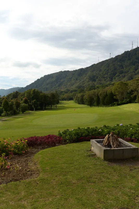 Serene golf course landscape with lush greenery, distant hills, and a tranquil atmosphere for relaxation and recreation outdoors