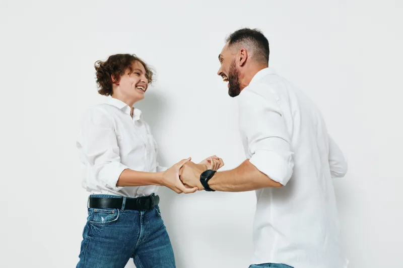 A professional man and colleague share a warm handshake against a clean, isolated colored background, conveying confidence, teamwork, and positive business emotions in a modern workplace vibe.