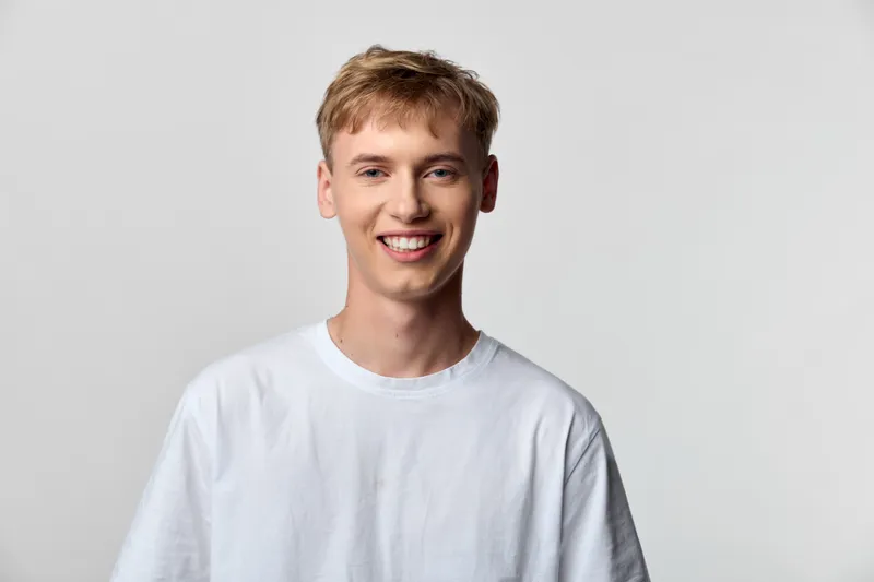 Smiling man wearing a white tshirt in a bright studio, casual and friendly mood, clean background, approachable and relaxed lifestyle stock photo