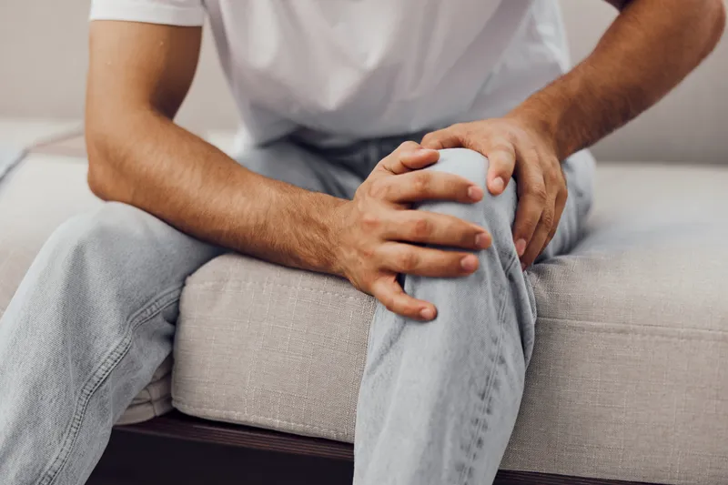 A thoughtful man sitting on a couch, reflecting on the impact of technology on mental health and the importance of emotional minimalism.