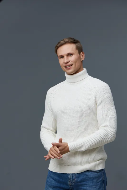 Smiling man casual white knitted turtleneck sweater standing isolated dark background happy positive emotions lifestyle concept