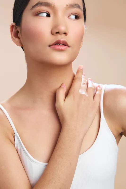 asian woman in a soft studio portrait, closeup view highlighting smooth skin and graceful expression, subtle makeup, calm confidence, and natural elegance.