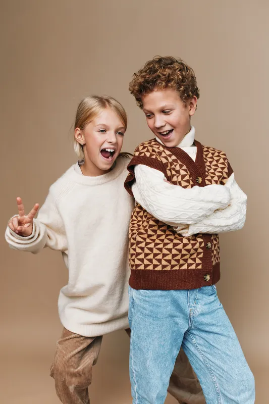 Authentic play scene shows young children in casual school age attire, capturing real emotion as they laugh, move, and explore through imaginative games.