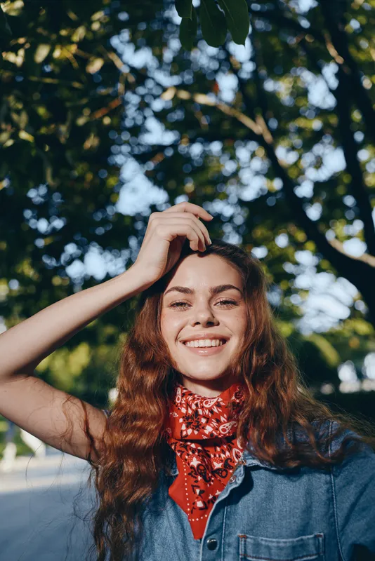 Lifestyle woman in modern boho-western denim street style smiling outdoors with natural light in film color, capturing joyful youth and relaxed urban vibe.