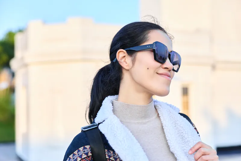 Sunglasses, woman, outdoors, fashion, style, confident expression with scarf and jacket under bright daylight, modern streetwear vibe capturing casual elegance and sunny mood.