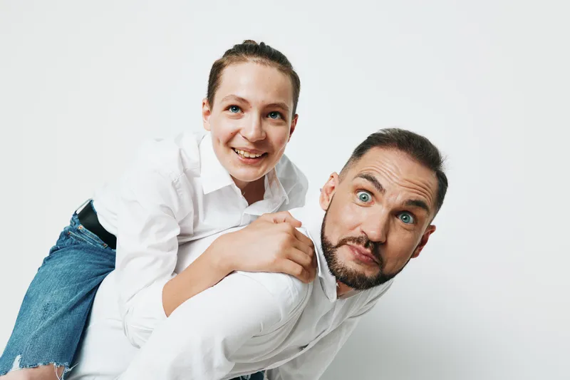 Professional man and colleague in a business setting against a solid color background, showcasing confident posture and positive emotions, ready for teamwork and leadership.
