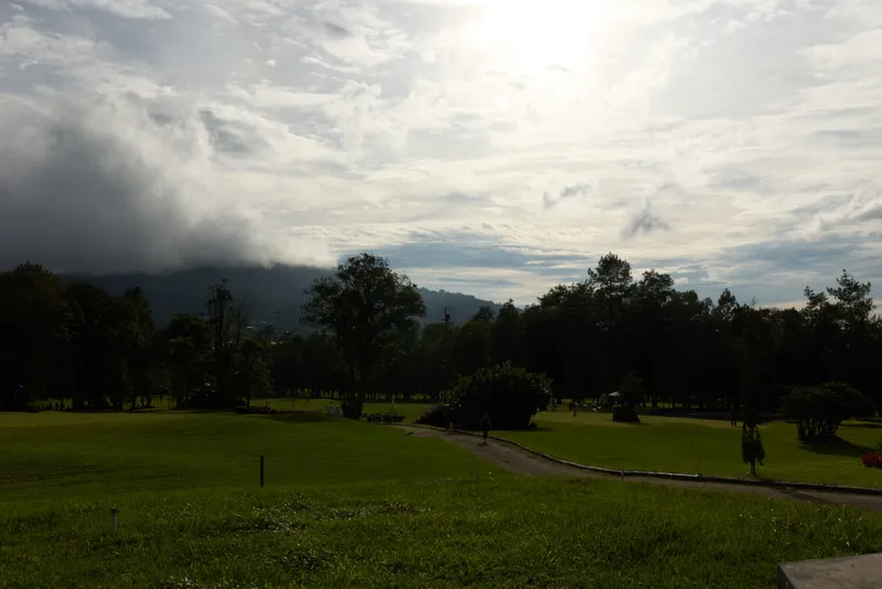 Serene landscape of a lush green golf course under a cloudy sky, perfect for relaxation and outdoor activities