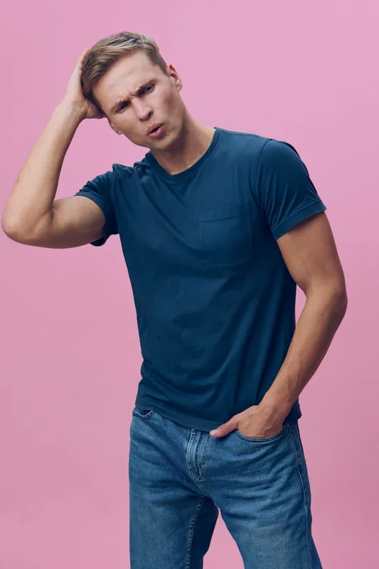 confused young caucasian man wear navy t-shirt blue jeans scratch head look puzzled isolated pink background studio portrait mental health concept