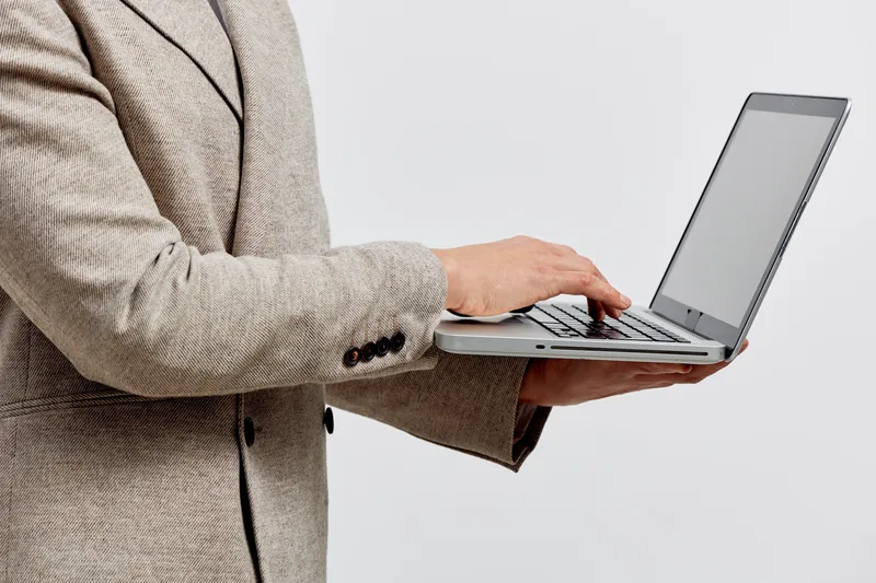 businessman holding laptop use technology digital nomad working concept with modern suit jacket isolated on gray background