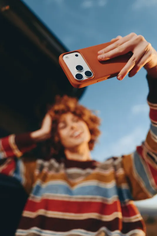 Outdoor woman lifestyle scene, smartphone in hand phone captures smiling child in park, family together in summer sunshine, candid lifestyle travel vibe, soft blur background