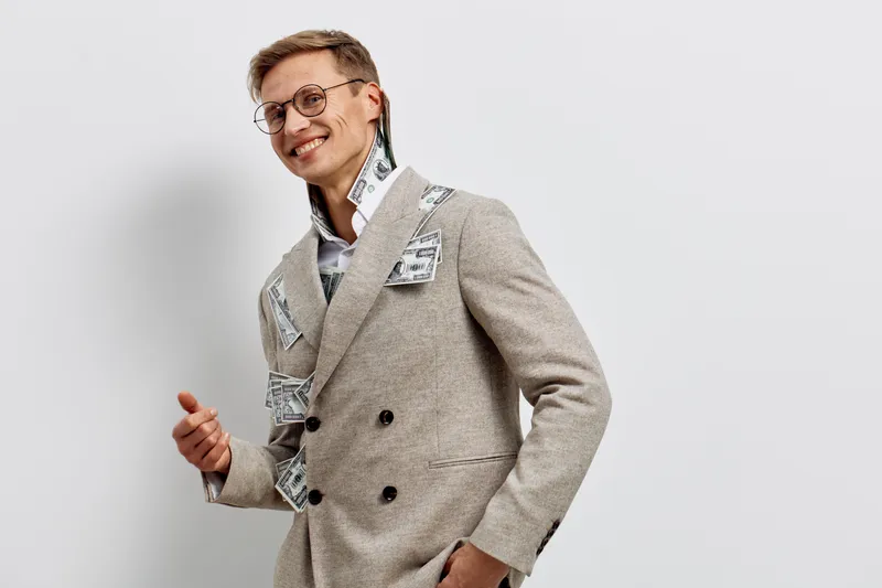 young smiling caucasian man wearing suit with banknotes cyber security concept standing isolated white background