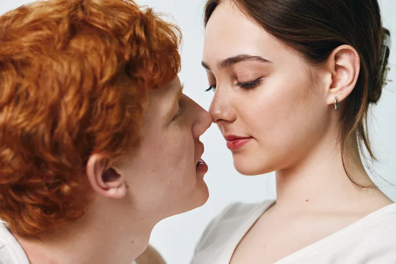 Couple, man and woman close with intimacy for love, romance and affection on white background. Relationship, togetherness and young people with emotional connection for dating and trust.